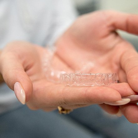 Closeup of patient holding clear aligner