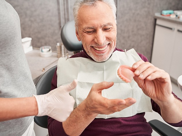 Patient in dentist’s chair receiving dentures