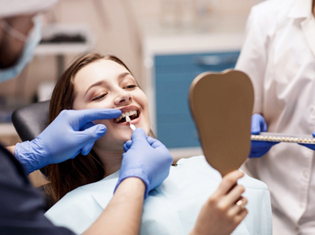 A dentist preparing a patient for her smile makeover