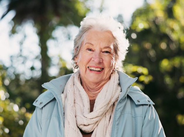 Patient smiling with her dentures outdoors