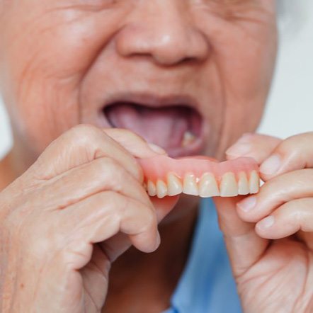 Close up of patient removing their denture