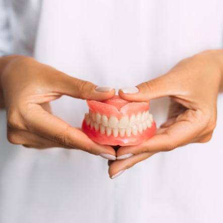 Close up of patient brushing their denture