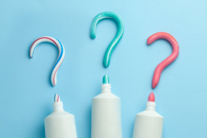 Three toothpaste bottles line up that have drawn question marks