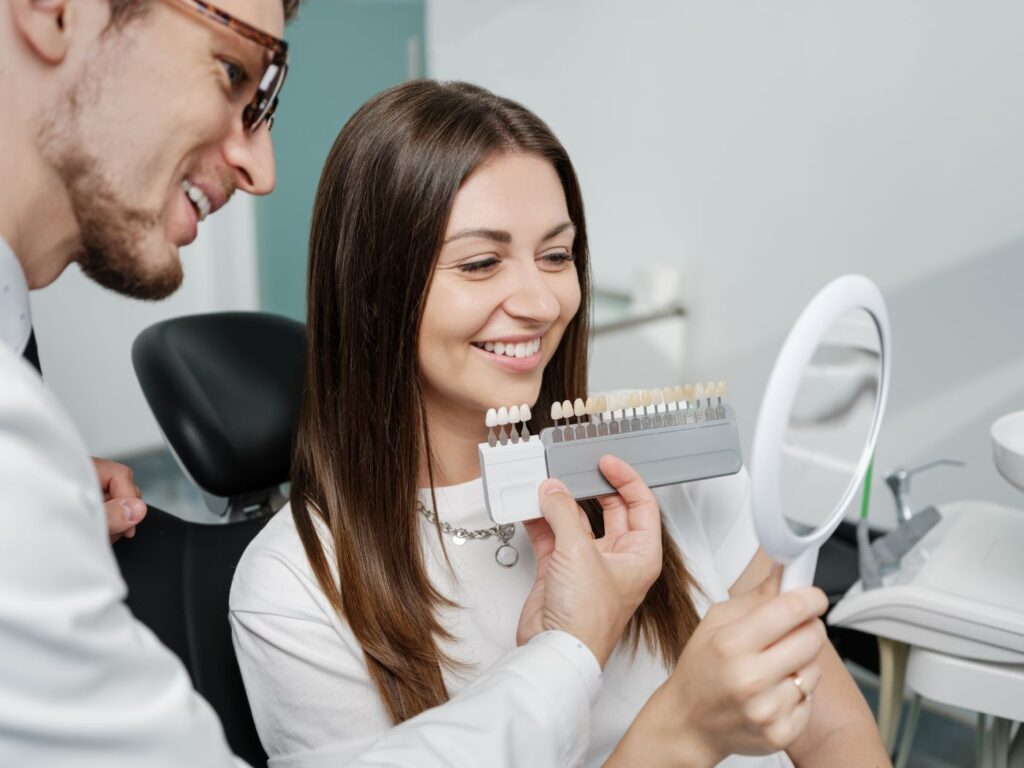 A woman selecting a veneer shade at the dentist's office.